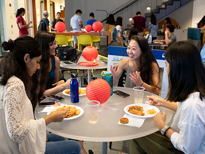Students enjoy food and conversation during an event in the CGL atrium.